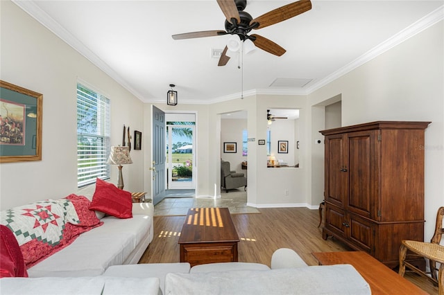 living room featuring light hardwood / wood-style flooring, ceiling fan, and crown molding