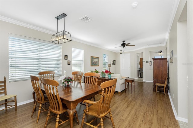 dining space featuring light wood-type flooring, ceiling fan, and ornamental molding