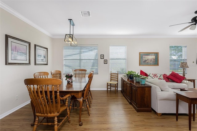 dining space featuring ceiling fan, dark wood-type flooring, and ornamental molding