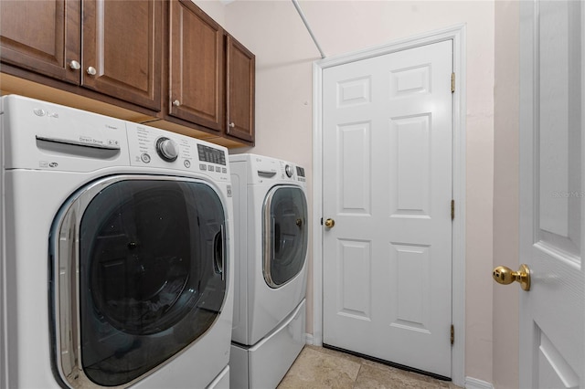 laundry room featuring cabinets and washing machine and dryer