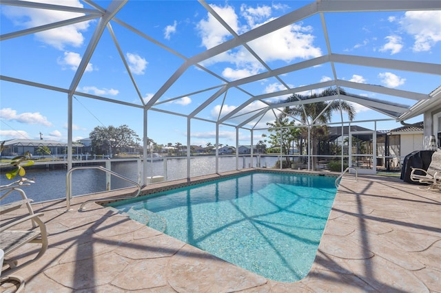 view of swimming pool featuring a patio area, glass enclosure, and a water view