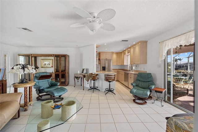 living room with sink, ceiling fan, plenty of natural light, and light tile patterned floors