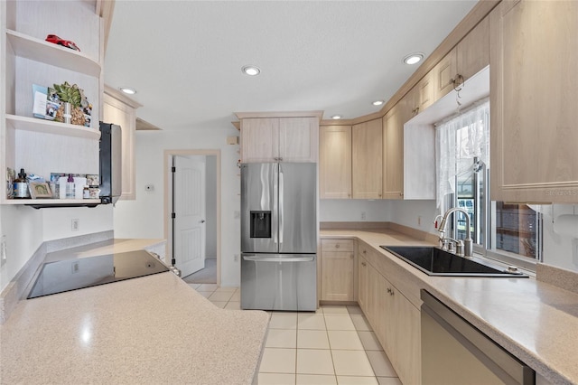 kitchen featuring appliances with stainless steel finishes, light brown cabinetry, sink, and light tile patterned floors