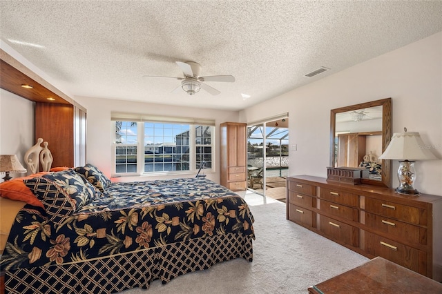 carpeted bedroom featuring access to outside, a textured ceiling, and ceiling fan