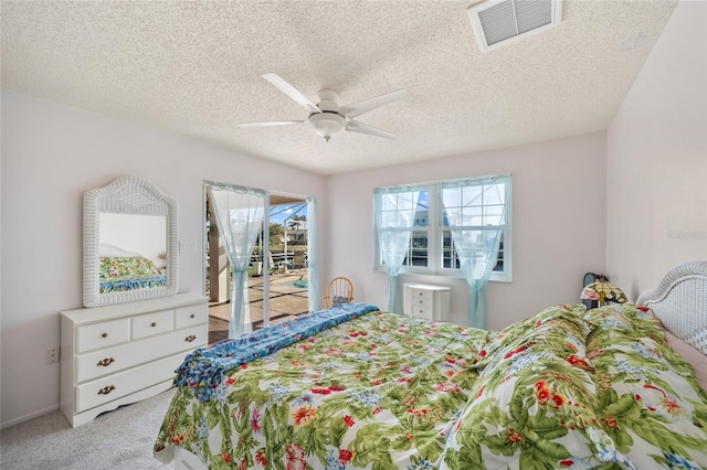 carpeted bedroom featuring a textured ceiling and ceiling fan