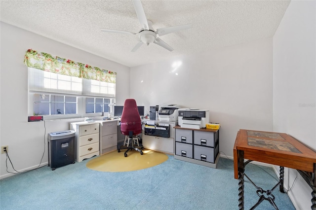 office area with a textured ceiling, ceiling fan, and light carpet