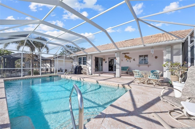 view of pool featuring a patio area, ceiling fan, and glass enclosure