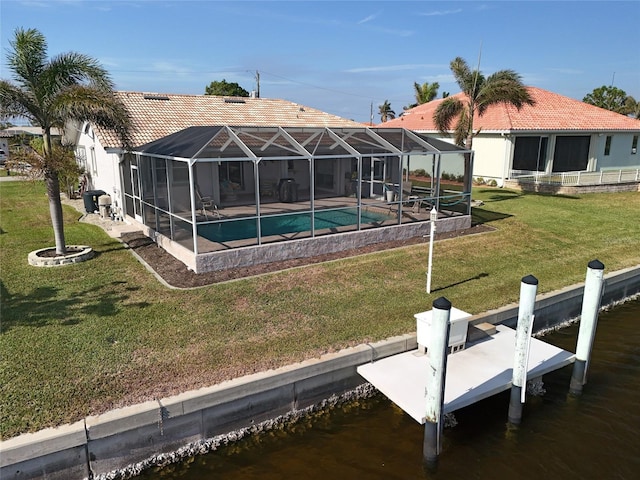 dock area with a lanai, a yard, and a water view