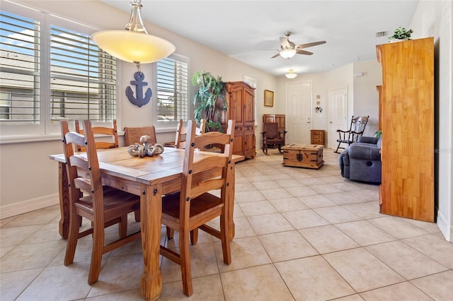 tiled dining space with ceiling fan