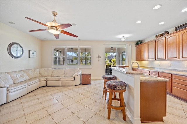 kitchen featuring a kitchen breakfast bar, sink, light tile patterned flooring, and plenty of natural light