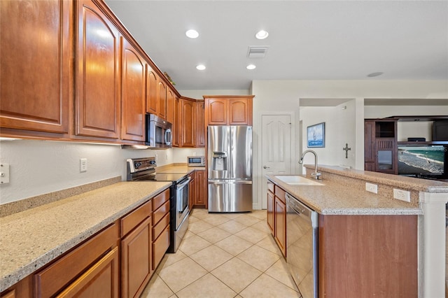 kitchen featuring sink, stainless steel appliances, light stone counters, an island with sink, and light tile patterned flooring