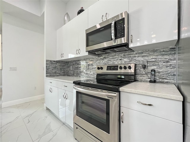 kitchen featuring appliances with stainless steel finishes, tasteful backsplash, and white cabinetry