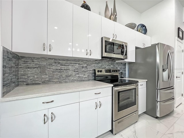 kitchen featuring tasteful backsplash, white cabinetry, and stainless steel appliances