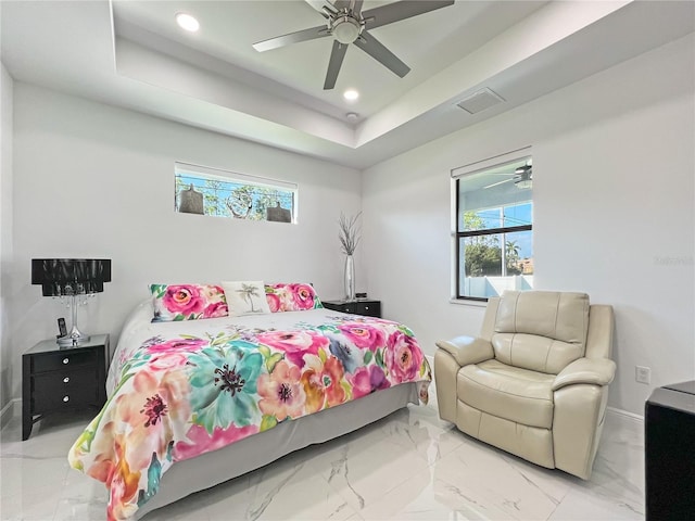 bedroom with a raised ceiling and ceiling fan