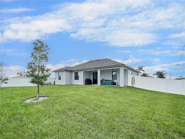 rear view of house featuring a yard