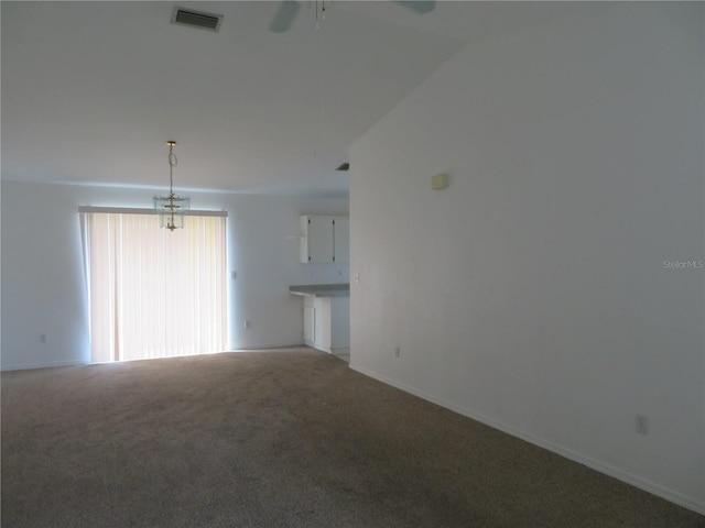 unfurnished living room with ceiling fan with notable chandelier, carpet floors, and lofted ceiling