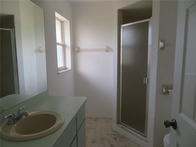 bathroom featuring vanity, toilet, and a shower with door