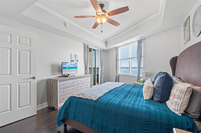 bedroom with a tray ceiling, crown molding, ceiling fan, and dark wood-type flooring