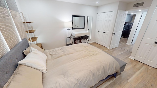 bedroom with light hardwood / wood-style floors and washer / clothes dryer