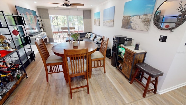 dining space with ceiling fan, crown molding, and light wood-type flooring