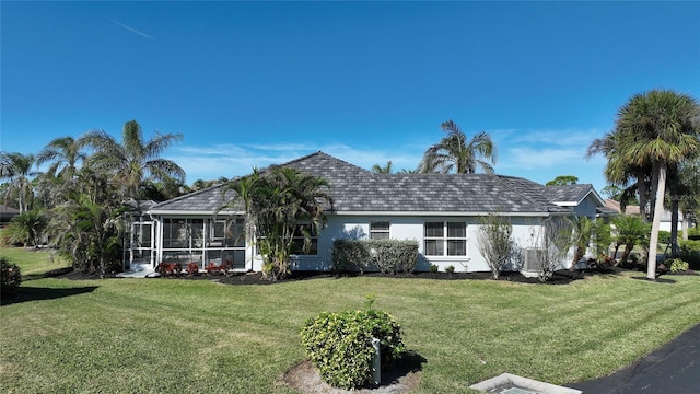 rear view of house with a lawn and a sunroom