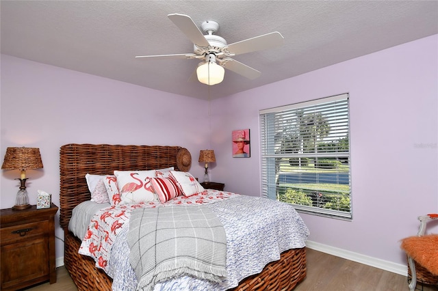 bedroom featuring a textured ceiling, hardwood / wood-style flooring, and ceiling fan