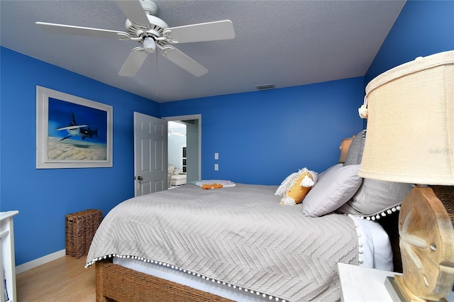 bedroom featuring ceiling fan, light hardwood / wood-style floors, and a textured ceiling