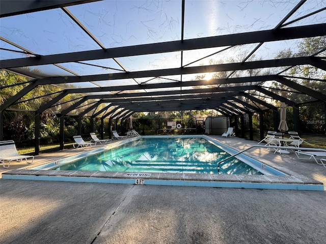 view of pool featuring glass enclosure and a patio