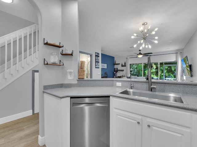 kitchen featuring white cabinets, ceiling fan with notable chandelier, sink, stainless steel dishwasher, and light hardwood / wood-style floors