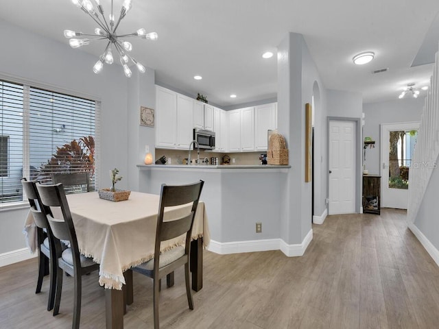 dining room featuring light hardwood / wood-style floors and a notable chandelier