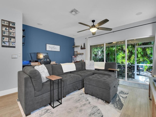 living room with ceiling fan and light hardwood / wood-style flooring