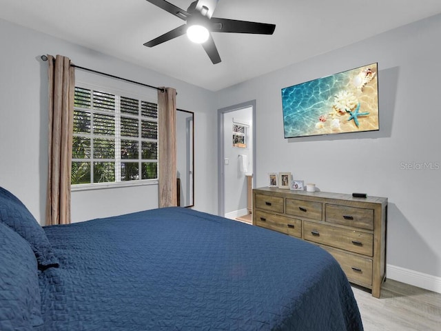 bedroom featuring ceiling fan, light wood-type flooring, and ensuite bath