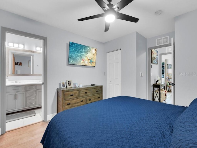 bedroom with ceiling fan, ensuite bathroom, and light wood-type flooring