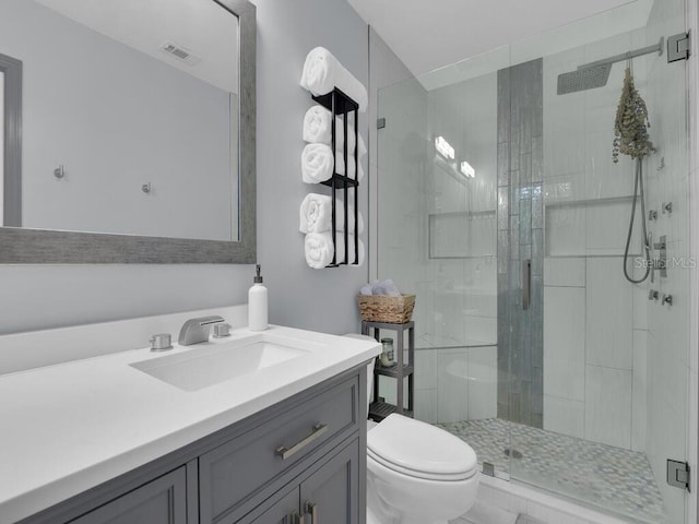 bathroom with an enclosed shower, vanity, and toilet