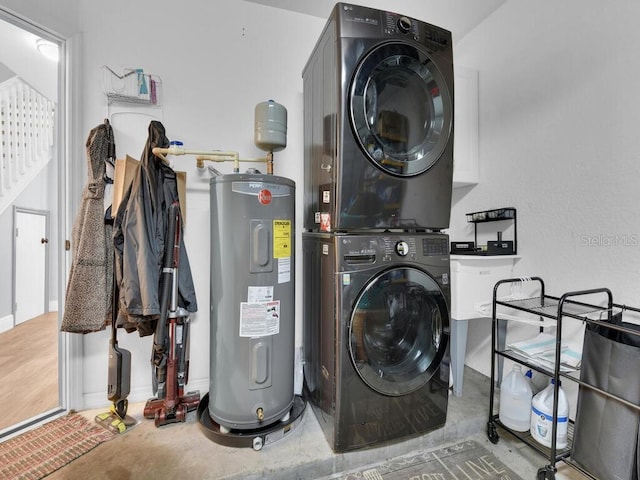 laundry area featuring stacked washer / dryer and water heater