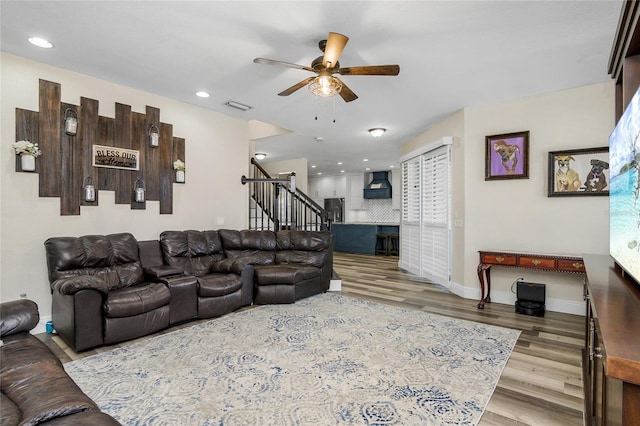 living room featuring light wood-type flooring and ceiling fan