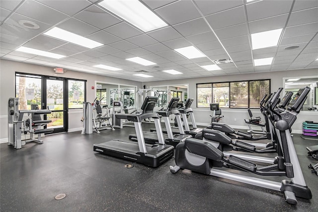 exercise room with a paneled ceiling and plenty of natural light