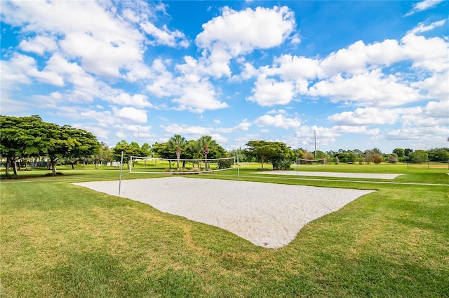 view of property's community with volleyball court and a lawn