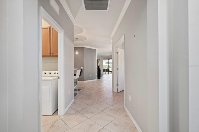 corridor featuring washer / dryer, light tile patterned floors, and crown molding