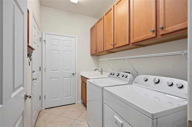 laundry area featuring cabinets, independent washer and dryer, light tile patterned floors, and sink