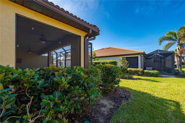 view of yard featuring a lanai and a ceiling fan