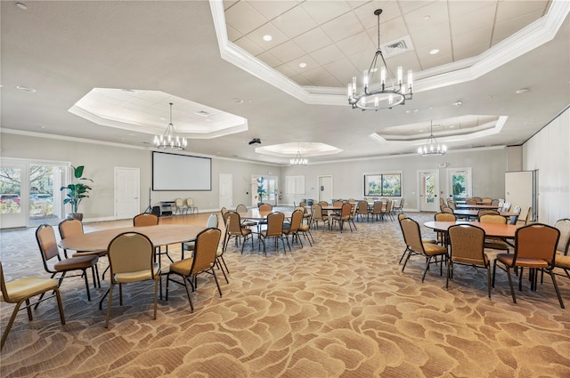 dining area with a chandelier, a raised ceiling, and visible vents