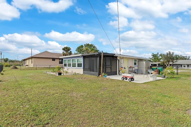 back of house with central AC, a patio area, a sunroom, and a lawn