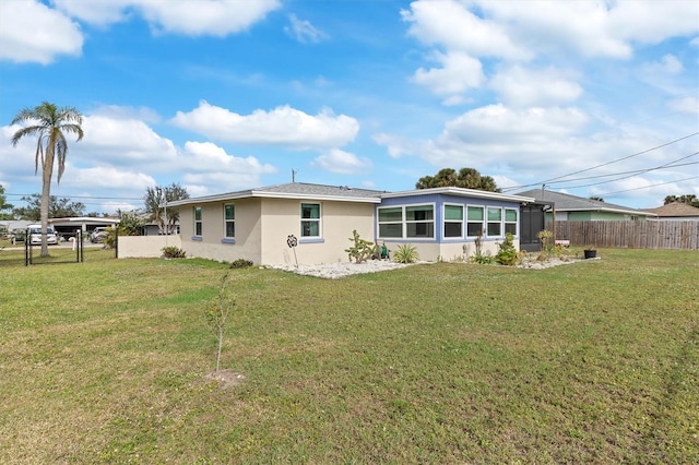 back of house featuring a yard and a sunroom