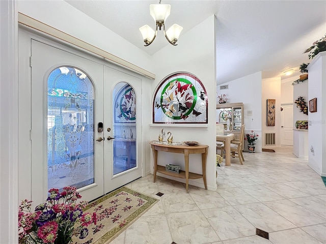 entrance foyer with a chandelier, french doors, and lofted ceiling