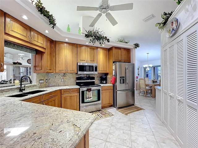 kitchen with sink, stainless steel appliances, backsplash, decorative light fixtures, and ceiling fan with notable chandelier