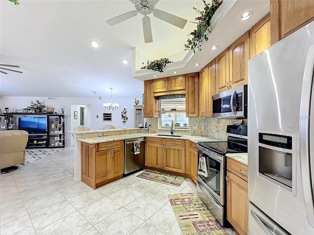 kitchen with ceiling fan with notable chandelier, hanging light fixtures, sink, appliances with stainless steel finishes, and kitchen peninsula