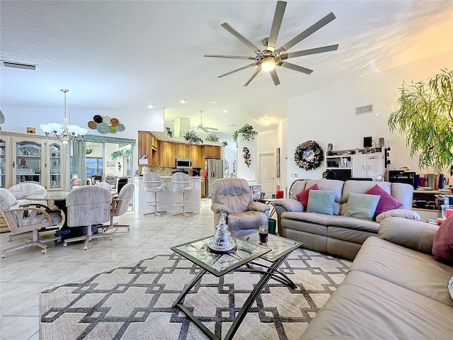 tiled living room featuring ceiling fan with notable chandelier