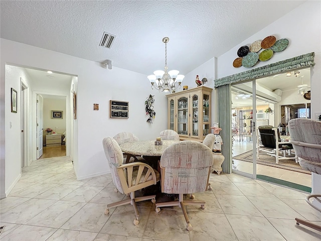 dining area with a chandelier and a textured ceiling