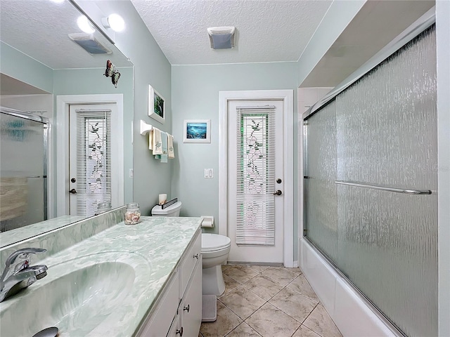 full bathroom with tile patterned flooring, enclosed tub / shower combo, a textured ceiling, toilet, and vanity